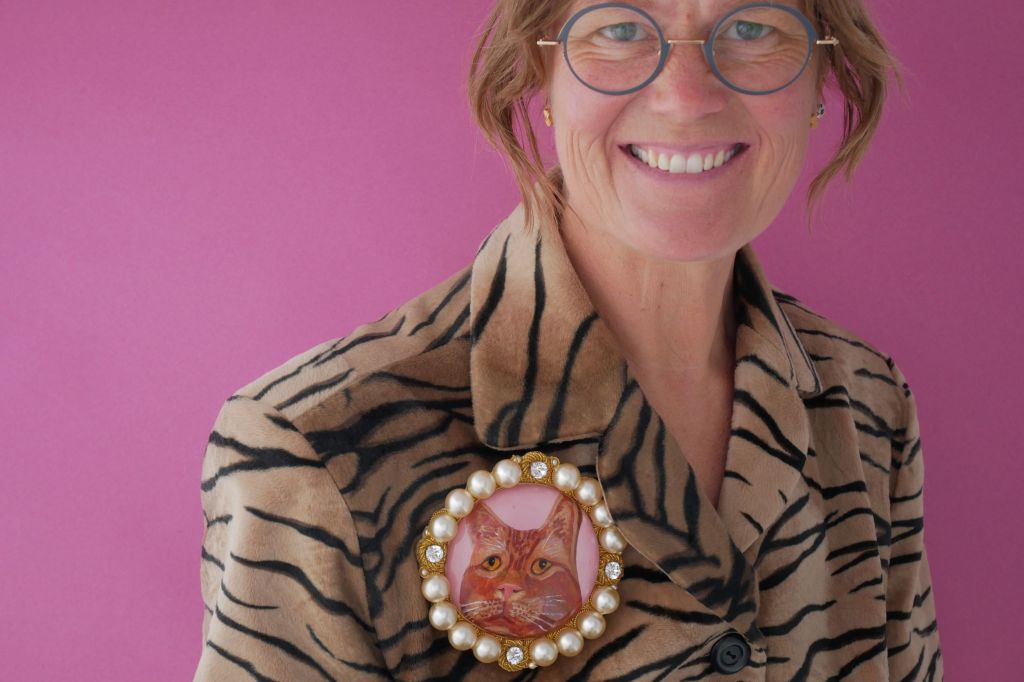 Picture of cast, engrved and enamelled borrch of a cat pinned to a fauz tiger skin coat worn by a woman